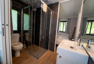 Bagno moderno con box doccia, wc e lavabo al Cottage Next XL Panorama, Trasimeno Glamping Resort, Italia.