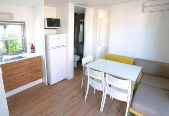 Cocina moderna y comedor en la Cottage Next XL Superior del Trasimeno Glamping Resort en Italia.
