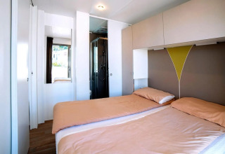 Camera luminosa con due letti singoli e moderno arredo al Cottage Next XL Superior del Trasimeno Glamping Resort, Italia.