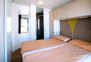 Habitación luminosa con dos camas individuales en el Cottage Next XL Superior de Trasimeno Glamping Resort, Italia.