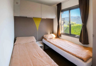 Due letti singoli con lenzuola beige in una luminosa camera del Cottage Next XL Superior, Trasimeno Glamping Resort, Italia.