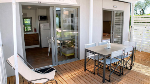 Terrazza con tavolo da pranzo e sedie al Cottage Next XL Superior presso Trasimeno Glamping Resort in Italia.