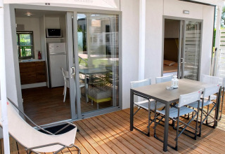 Terrazza con tavolo da pranzo e sedie al Cottage Next XL Superior presso Trasimeno Glamping Resort in Italia.