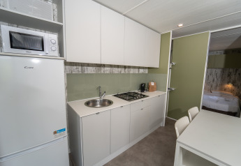 Cocina moderna y comedor en una Cottage Next XL Loggia Laguna del Trasimeno Glamping Resort en Italia.
