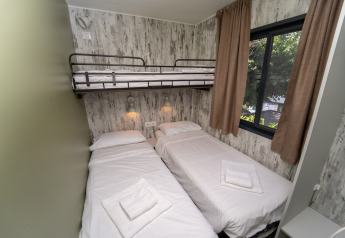 Habitación con dos camas individuales y una litera superior en Cottage Next XL Loggia Laguna, Trasimeno Glamping Resort.