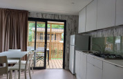 Cucina moderna e zona pranzo nel Cottage Next XL Loggia al Trasimeno Glamping Resort, Italia.