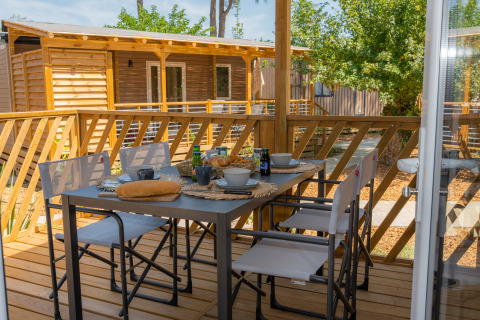 Terraza exterior de Cottage Next XL Country en Trasimeno Glamping Resort, Italia, mesa puesta para desayuno.