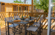 Terrazza esterna al Cottage Next XL Country del Trasimeno Glamping Resort, Italia, apparecchiata per la colazione.