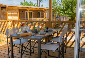 Terraza exterior de Cottage Next XL Country en Trasimeno Glamping Resort, Italia, mesa puesta para desayuno.