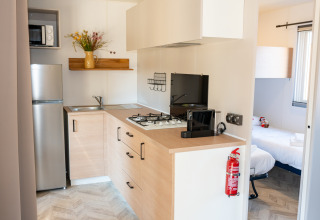 Cocina moderna y dormitorio en Cottage Next XL Mercure, Trasimeno Glamping Resort, Italia.