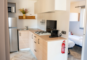 Cocina moderna y dormitorio en Cottage Next XL Mercure, Trasimeno Glamping Resort, Italia.