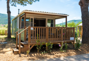 Vista exterior del alojamiento Cottage Classic Suite con porche de madera y paisaje natural al fondo.