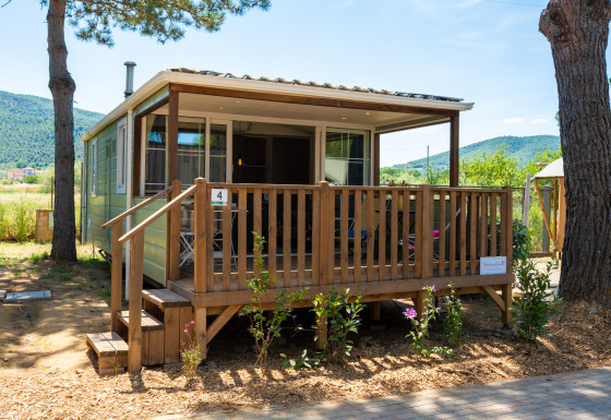 Vista exterior del alojamiento Cottage Classic Suite con porche de madera y paisaje natural al fondo.