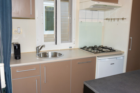 Cocina compacta en la Suite Cottage Classic del Trasimeno Glamping Resort con fregadero y estufa de gas.
