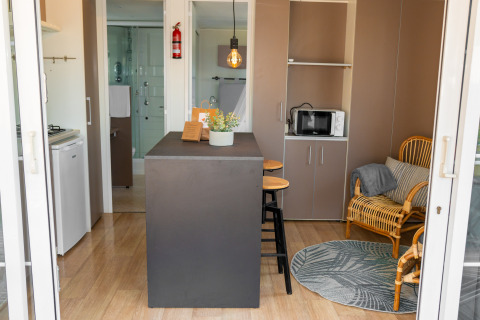 Vista interior de la Suite Cottage Classic en Trasimeno Glamping Resort, con mobiliario moderno y barra central.