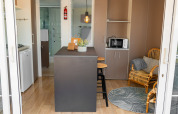 Vista interna della Cottage Classic Suite al Trasimeno Glamping Resort, con arredi moderni e isola centrale.