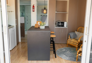 Vista interior de la Suite Cottage Classic en Trasimeno Glamping Resort, con mobiliario moderno y barra central.