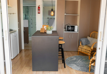 Vista interior de la Suite Cottage Classic en Trasimeno Glamping Resort, con mobiliario moderno y barra central.