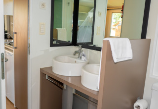 Baño moderno con doble lavabo y espejo en la suite Cottage Classic del Trasimeno Glamping Resort en Italia.