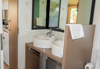 Baño moderno con doble lavabo y espejo en la suite Cottage Classic del Trasimeno Glamping Resort en Italia.