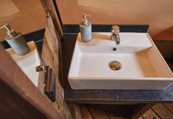 Moderne wastafel met zeepdispenser in de Tipi Lodge bij Trasimeno Glamping Resort, Italië.
