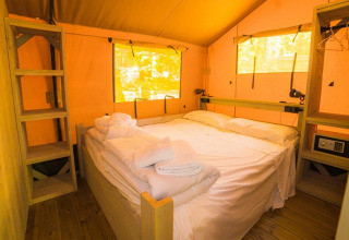Gezellige slaapkamer in een safaritent met tweepersoonsbed bij Spotty Lodge, Trasimeno Glamping Resort, Italië.
