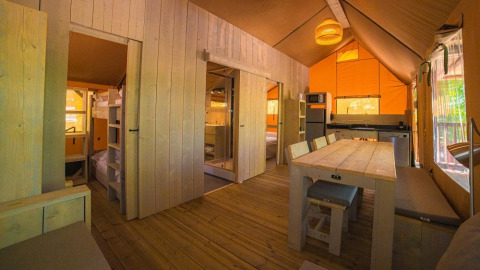 Binnenkant van de Spotty Lodge Ranger safaritent op Trasimeno Glamping Resort met houten inrichting in Italië.