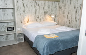 Camera moderna presso Cottage Next XL 4 All, Trasimeno Glamping Resort, con letto matrimoniale e libro aperto.