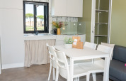 Cucina moderna e zona pranzo al Cottage Next XL 4 All del Trasimeno Glamping Resort in Italia.