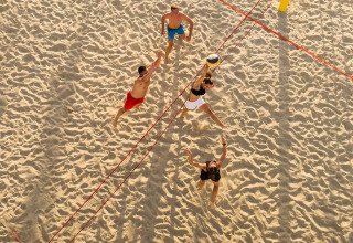 Vista aerea di quattro persone che giocano a beach volley sulla sabbia vicino a Baška, Croazia, soleggiata.