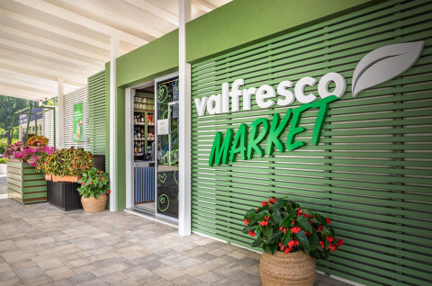 Ingresso del Valfresco Market al campeggio Baška con facciata verde e fiori in Croazia.