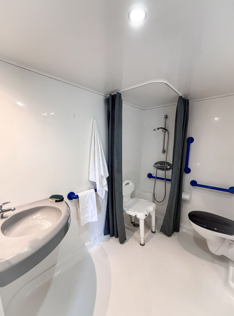 Accessible bathroom in the Stacaravan Confort at Camping Demoiselles Plage, France, with support rails.