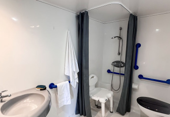 Accessible bathroom in the Stacaravan Confort at Camping Demoiselles Plage, France, with support rails.