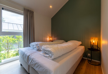 Camera da letto in Wellness Cottage con vasca idromassaggio e sauna privata a De Thijmse Berg, Paesi Bassi.