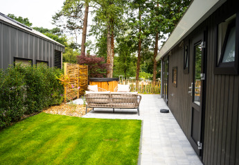 Area relax esterna al Wellness Cottage con vasca idromassaggio privata e sauna a De Thijmse Berg, Olanda.