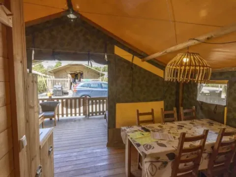 Interieur van Safaritent Sorella met eetruimte, privébadkamer en airconditioning op Camping Polari, Kroatië.
