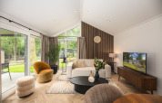 Moderne woonkamer in Doornenburg Lodge Comfort met grote ramen bij Veluwepark de Bosgraaf in Nederland.