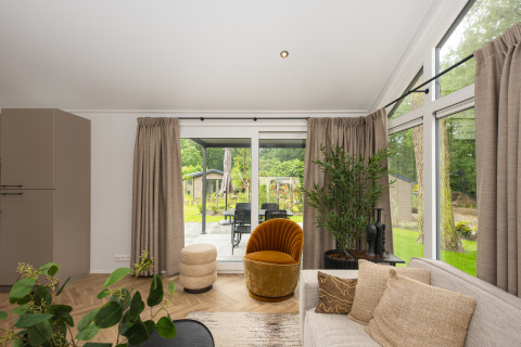 Lichte woonkamer in Doornenburg Lodge Comfort, Veluwepark de Bosgraaf, Nederland, met grote ramen.