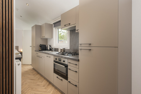 Modern kitchen at Doornenburg Lodge Comfort at Veluwepark de Bosgraaf in the Netherlands with gas stove.
