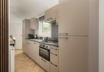 Cocina moderna en Doornenburg Lodge Comfort en Veluwepark de Bosgraaf, Países Bajos, con vitrocerámica.