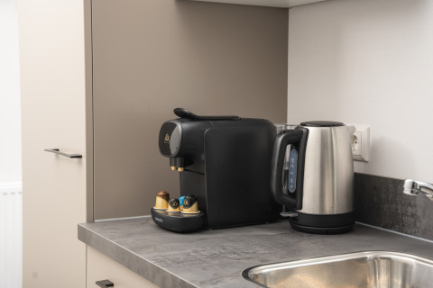 Moderne koffiemachine en waterkoker op het aanrecht in Doornenburg Lodge Comfort in Veluwepark de Bosgraaf.