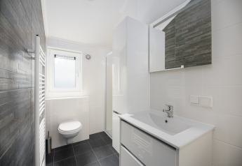 Moderne badeværelse på Doornenburg Lodge Comfort, Veluwepark de Bosgraaf, Nederlandene, med hvidt interiør.