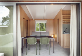 Interiør af Mobile home FAMILY på Wecamp Pirineos i Spanien, med spisebord og lille tekøkken.