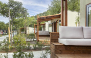Vue extérieure du lodge Mobile home FAMILY à Wecamp Pirineos en Espagne, terrasse et verdure en premier plan.