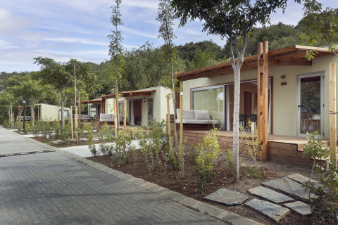Moderne mobile hjem med træterrasser og grønne omgivelser på Wecamp Pirineos lodge i Spanien.