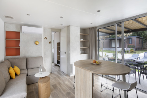 Moderne opholdsstue i Mobile home FAMILY XL på Wecamp Pirineos i Spanien med spisebord og udsigt.