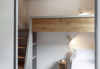 Modernes Schlafzimmer mit Etagenbett, Holzdetails und Leselampen im Mobile Home FAMILY XL, Wecamp Pirineos, Spanien.