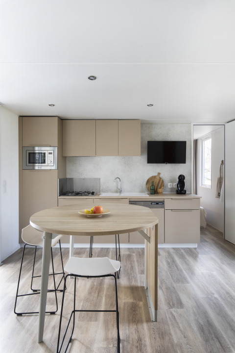 Moderne Küche und Essbereich im Mobile Home FAMILY XL bei Wecamp Pirineos, Spanien, mit stilvollem Design.
