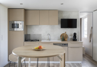Moderne køkken og spiseområde i Mobile home FAMILY XL på Wecamp Pirineos, Spanien, med minimalistisk indretning.