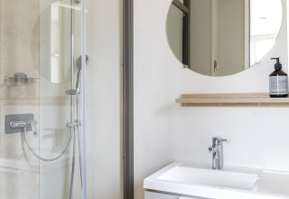 Modernes Badezimmer mit Dusche, Spiegel und Waschbecken im Mobile home FAMILY XL bei Wecamp Pirineos, Spanien.